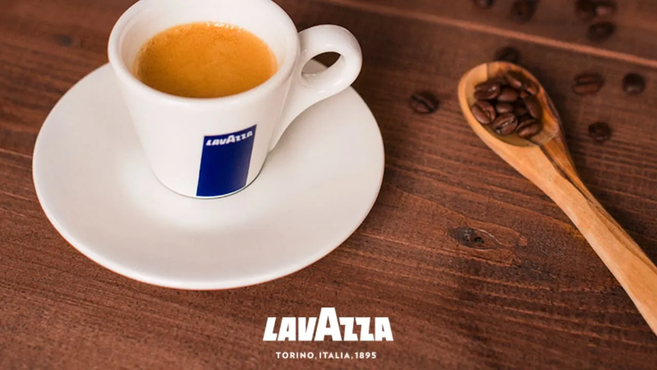 桌面上有咖啡豆、有一杯Lavazza濃縮精品咖啡